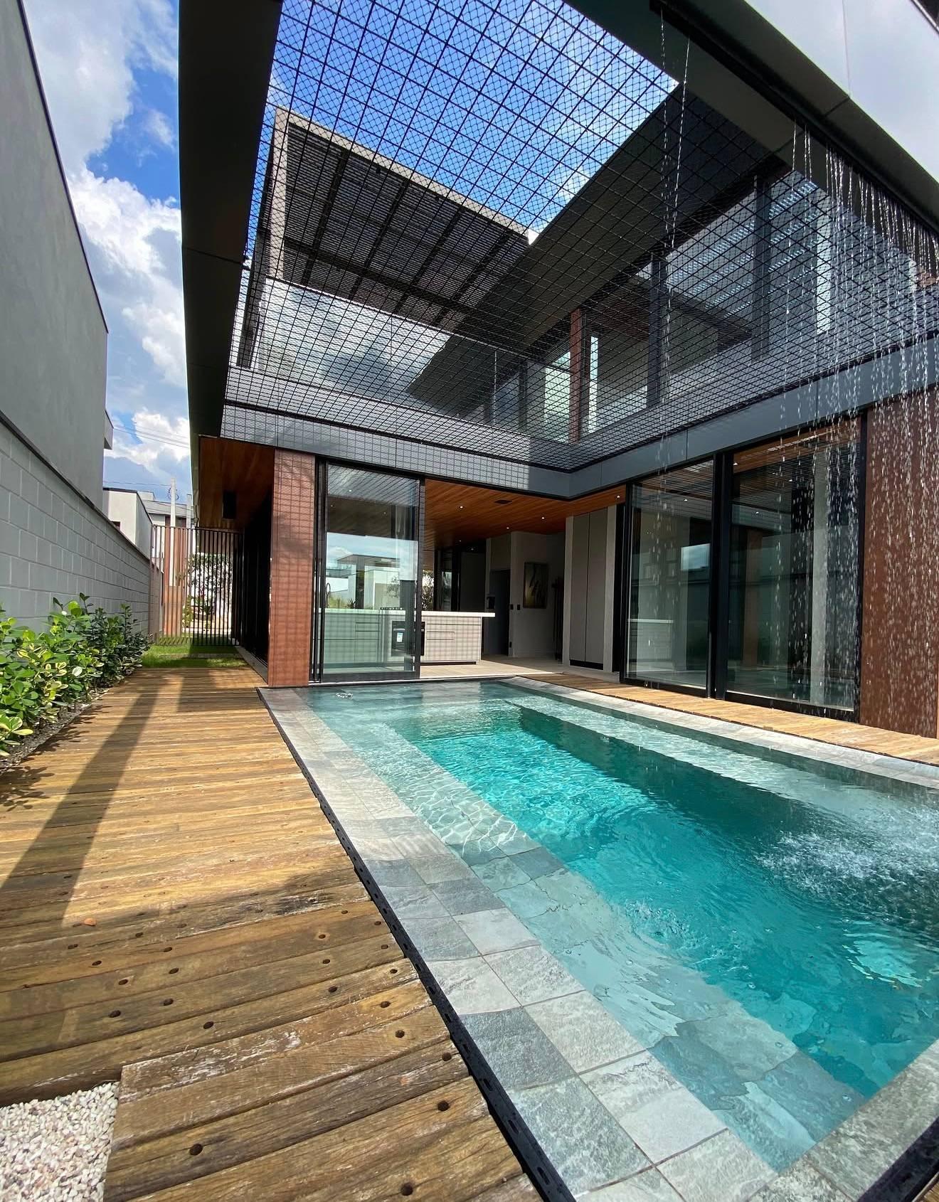 Piscina com cascata e deck em madeira de demolição